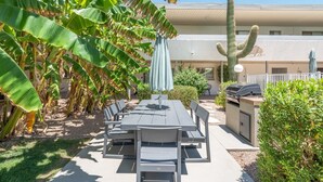 An outdoor patio with a table and chairs, a barbecue grill, and a cactus. - Walk to Old Town, Heated Pool, Fast Internet,  Continental Breakfast included.  (Scottsdale)