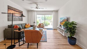 A modern living room with a sofa, armchair, and a large potted plant. - Walk to Old Town, Heated Pool, Fast Internet,  Continental Breakfast included.  (Scottsdale)