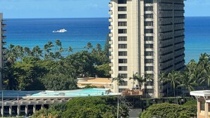 Un hotel alto con piscina y vistas al océano.