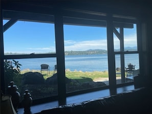 Enjoy a serene view of the lake and distant mountains from the large windows in this stylish room.
