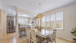A modern kitchen with a dining area, featuring a large island, stainless steel appliances, and ample natural light. - Private townhome steps from the beach and right next to the pool (Longboat Key)