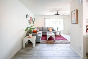 Relax in this stylish living room with a sofa, coffee table, side table, and potted plant.