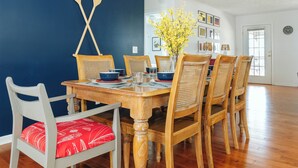 Un comedor con una mesa de madera, sillas y una lámpara colgante.