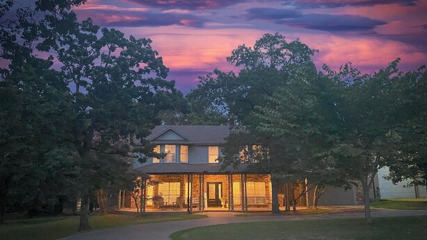A two-story house with a covered porch and a brick exterior.