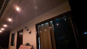 Un balcone con un letto, una finestra e una porta.