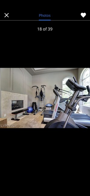 Stay fit on the go with a fully equipped home gym featuring a stationary bike, treadmill, and dumbbells.
