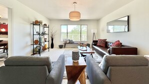 Una sala moderna con sofá, mesa de centro y estantería.