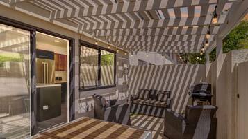 Une terrasse extérieure dotée d’une pergola, d’un espace salon et d’un barbecue.