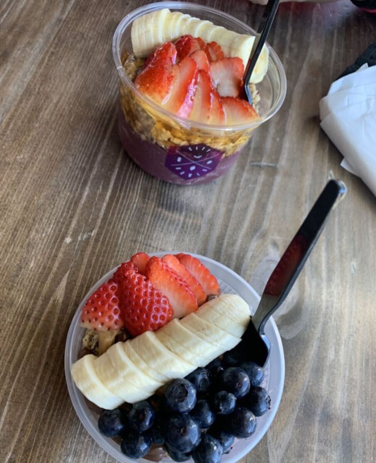 Twee schalen met fruitsalade, elk met een lepel.
