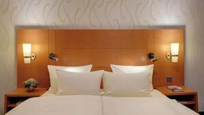 Ein Hotelzimmer mit einem großen Bett, zwei Nachttischen und Wandleuchten.