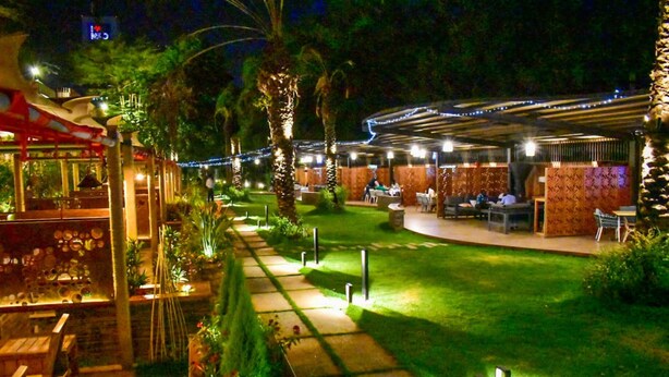 An outdoor restaurant area with a covered seating area, a pathway, and greenery. - Hotel Boulevard Nairobi, City Centre CBD (Nairobi)