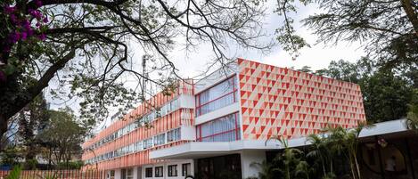 A modern building with a geometric facade, multiple floors, and a central entrance.