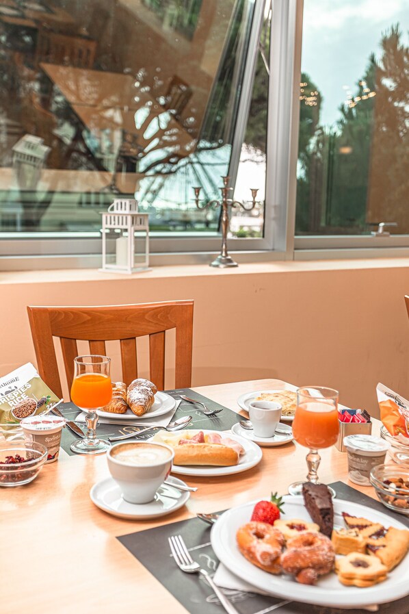 A breakfast table with pastries, a coffee cup, and a glass of orange juice. - Hotel Villa Maria (Cesenatico)