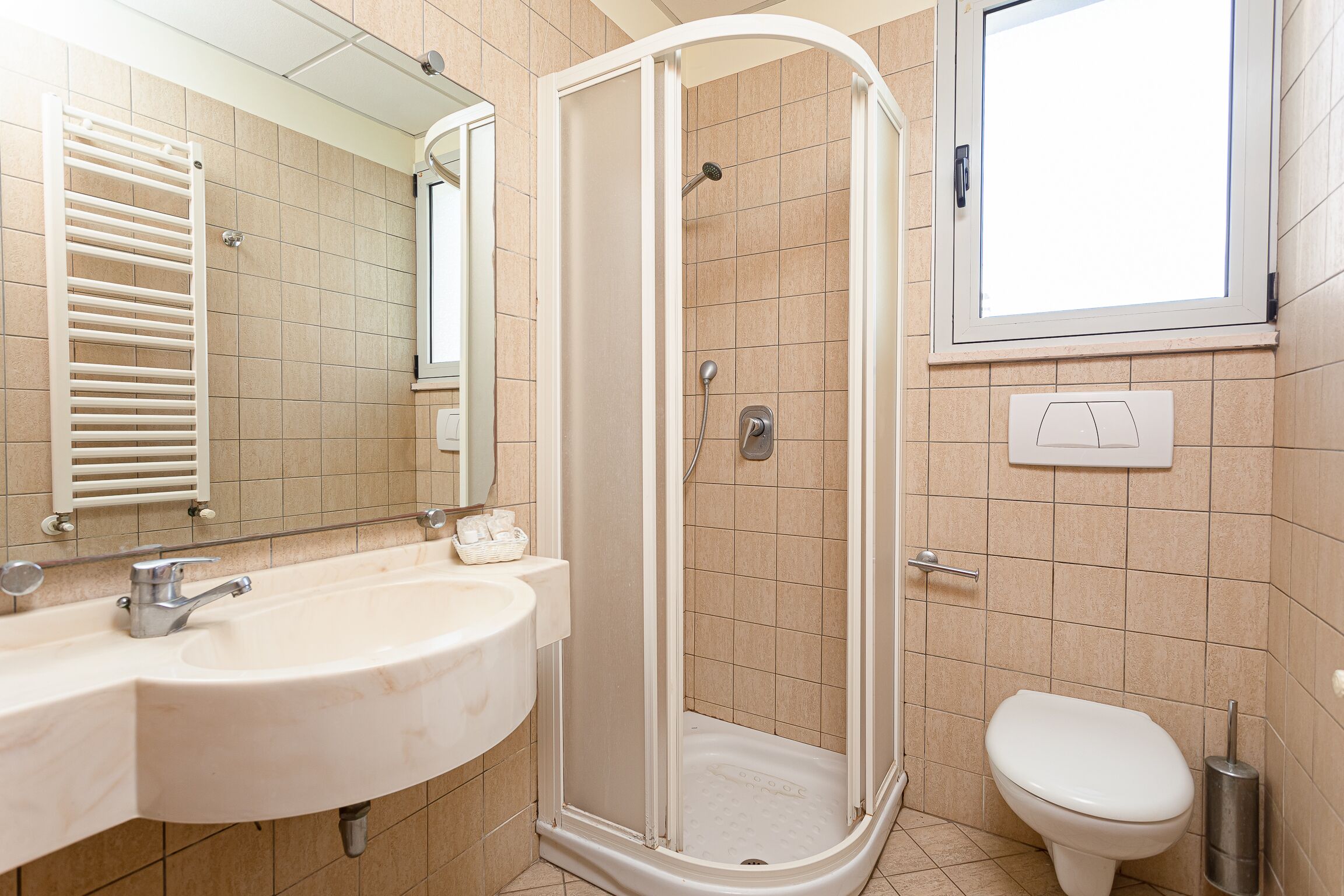 Baño con lavamanos, inodoro y ducha.