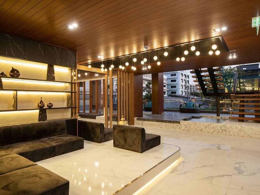 A modern lobby with a marble reception desk, plush seating, and a view of the street.