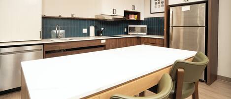 A modern kitchen with a central island, stainless steel appliances, and wooden cabinetry.