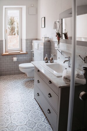 Un baño con inodoro, lavamanos y espejo.