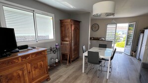 A spacious kitchen with a dining area, wooden cabinets, and a large window. - Comfortable vacation home ideally located between beach and town center (Saint-Hilaire-de-Riez)