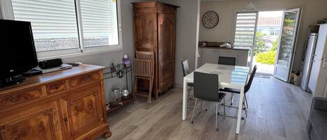 A spacious kitchen with a dining area, wooden cabinets, and a large window.