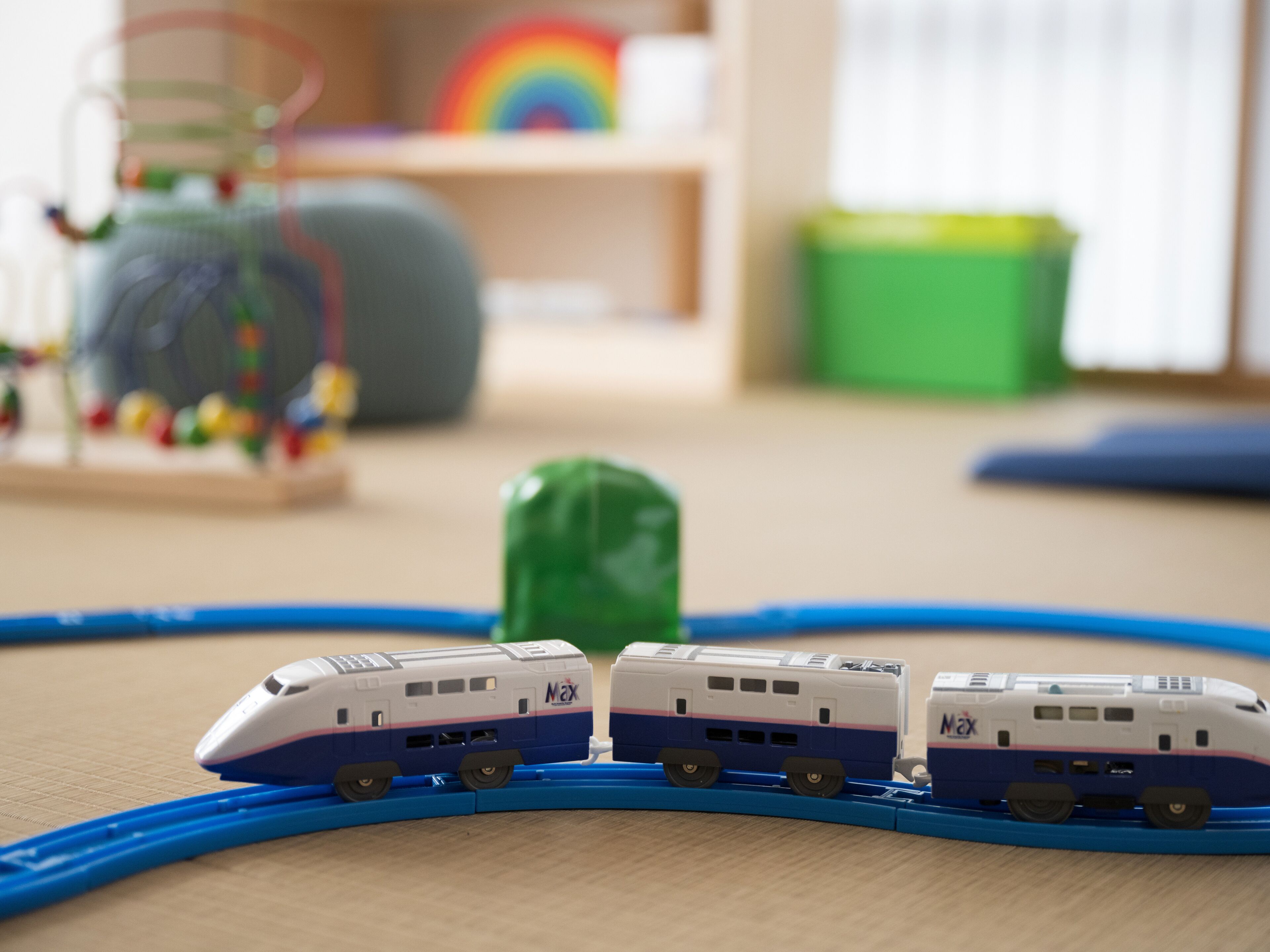 Un trenino in miniatura su un binario, con un oggetto verde al centro.