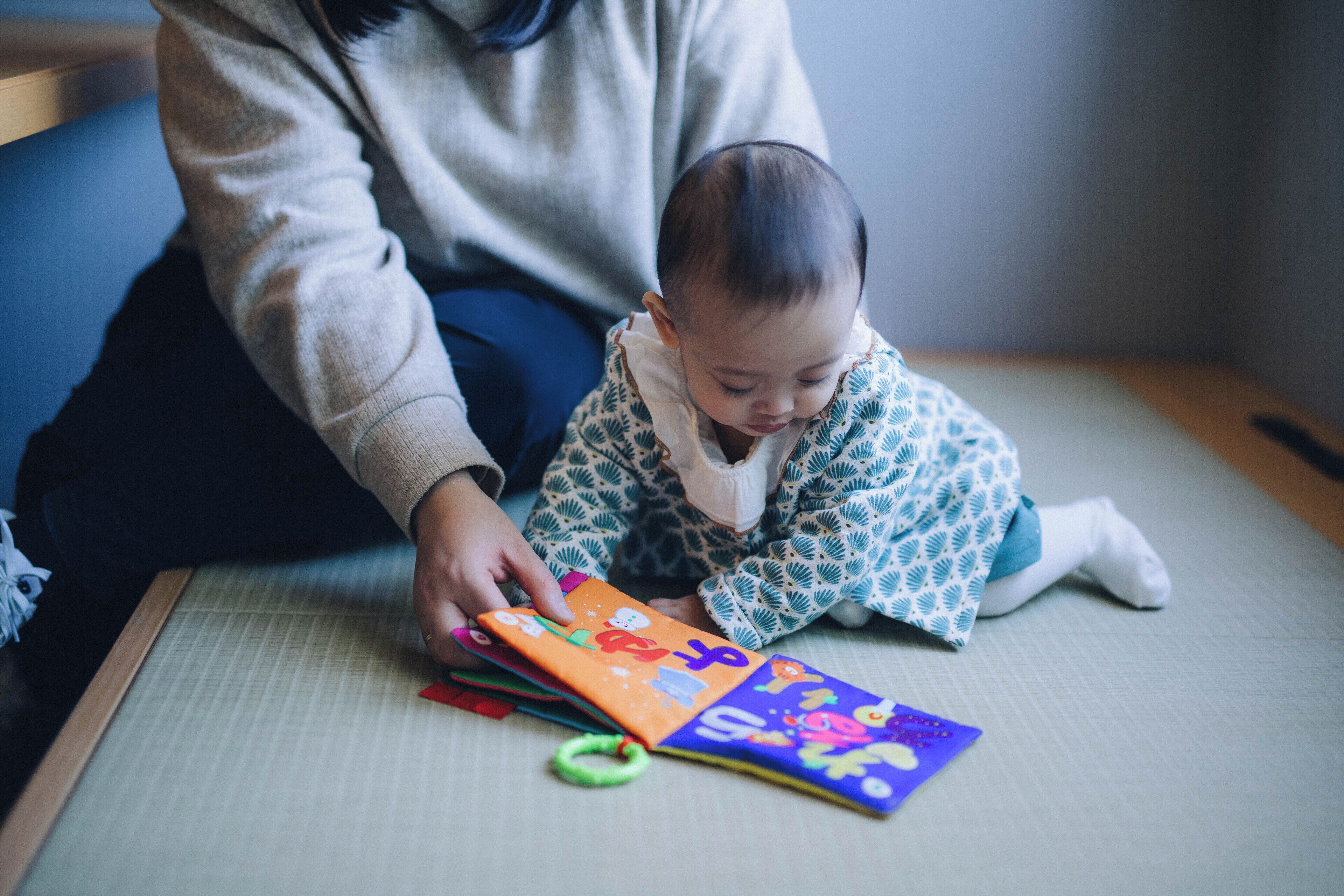 A person sitting on a tatami mat with a colorful book.