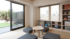 A modern reading room with large windows, a round table, and built-in bookshelves. - MIMARU Osaka Namba Station (Osaka)