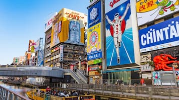A busy urban street with various commercial buildings, including a prominent billboard for Asahi beer.