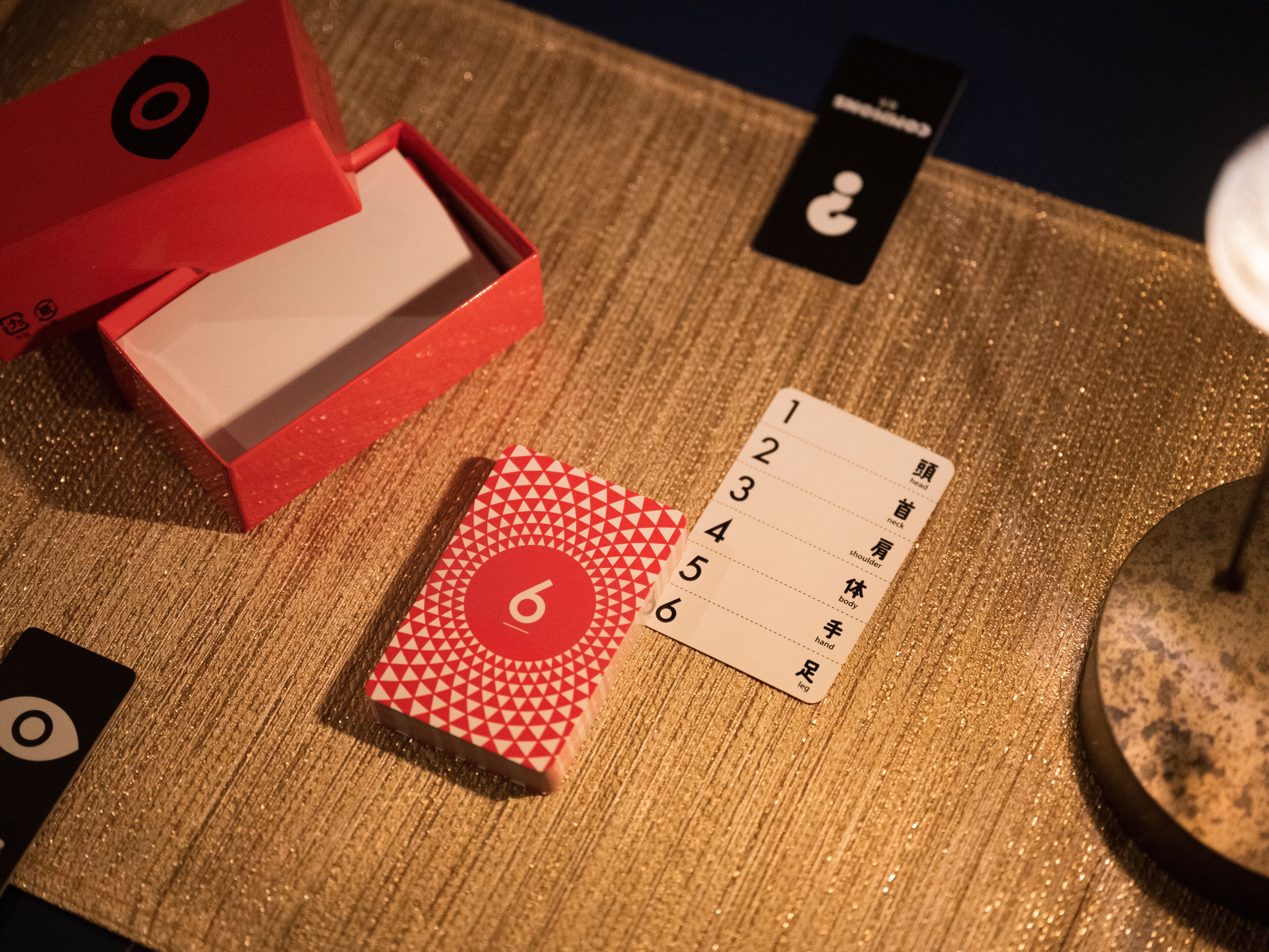 A card game setup with numbered cards and a red box on a textured surface.