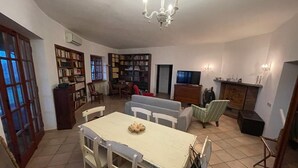 A spacious living room with a dining area, a fireplace, and a TV.