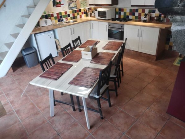 Cozy kitchen area with dining table for four, equipped with microwave, oven, and sink.