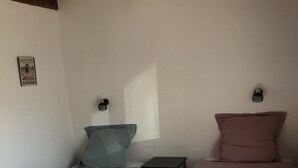A room with two beds, a small table, and a wall-mounted light fixture. - Luberon: between Aix and Lourmarin (VILLELAURE)
