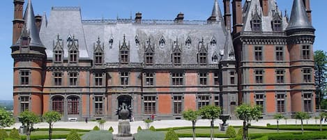A large, historic building with multiple towers and a symmetrical facade.