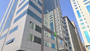 A modern high-rise building with a glass facade, labeled "Time Moonstone." - TIME Moonstone Hotel Apartments (Al-Fujairah)