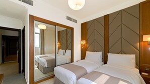 A hotel room with two beds, a large mirror, and a wooden headboard. - TIME Moonstone Hotel Apartments (Al-Fujairah)