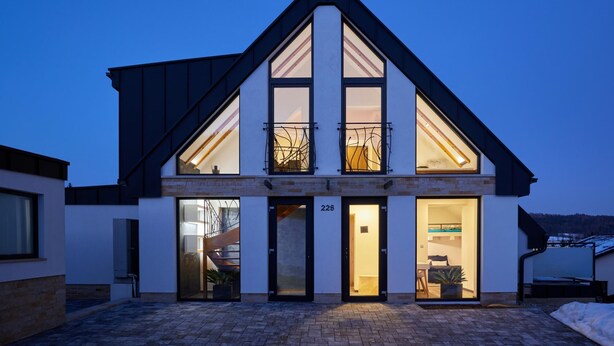 A modern two-story house with a steep gable roof, large windows, and a visible staircase leading to the upper floor. - Radvanice Kcg351 in Radvanice (Radvanice)