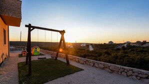 A patio with a swing set, a small play area, and a view of the surrounding landscape. - Villa Ba i Zadarvillas (Sukosan)