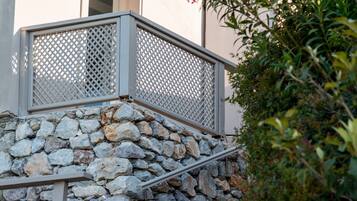 Eine Steintreppe mit Metallgeländern, die zu einem Hauseingang führt.