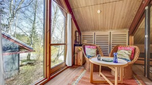 A cozy room with a large window, wooden ceiling, and a table with chairs. - 2 bedroom cozy home in Dronningmølle (Dronningmølle)