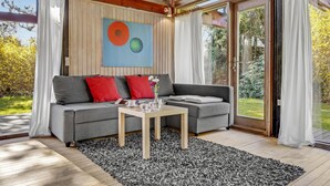 A modern living room with a grey sofa, red cushions, a coffee table, and a painting. - 2 bedroom cozy home in Dronningmølle (Dronningmølle)