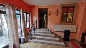 Eine Treppe führt zu einer zweiten Etage, auf dem Landeplatz befinden sich ein Heizkörper und ein Lautsprecher.