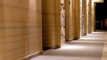 A long, well-lit hallway with uniform doors and a clean, tiled floor.