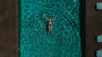 Alberca al aire libre, sombrillas en la alberca y camastros