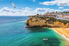 Un pueblo costero con edificios sobre un acantilado con vista a aguas turquesas.