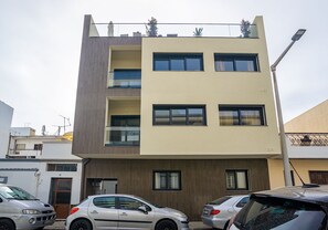 Un edificio residencial de varios pisos con un diseño moderno, que cuenta con balcones y ventanas amplias.