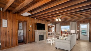 A spacious living area with a fireplace, a television, and a sofa.
