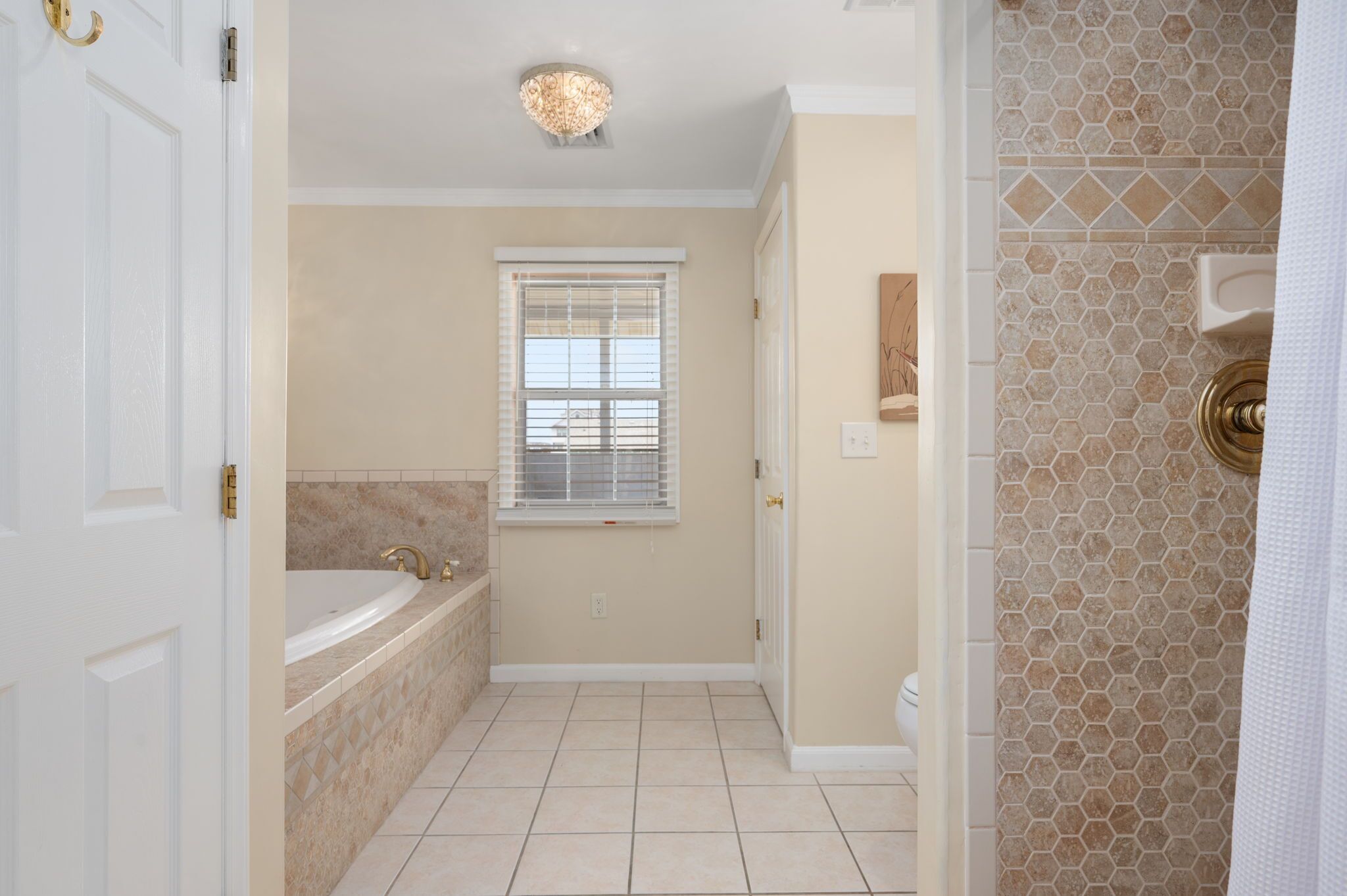 A bathroom with a bathtub, a window, and a shower area.