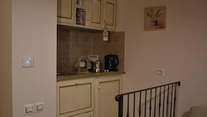 Een kleine keuken met een houten trap naar een woongedeelte.