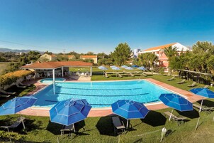 Una piscina al aire libre de temporada, sombrillas