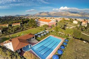 En säsongsöppen utomhuspool, parasoller och solstolar