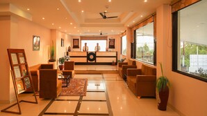A hotel lobby with a reception desk, seating area, and large windows offering a view. - Hotel 360 By D'Polo Dharamshala (Dharamshala)
